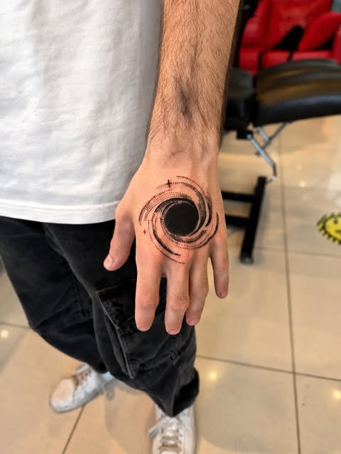 El üstüne uygulanmış dotwork tekniğiyle kara delik dövmesi